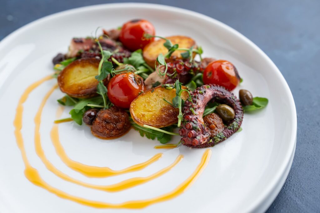 Nakládaná chobotnice Mediterraneo - Středomořská kuchyně v restauraci Na Krétě. Zažijte skvělé gastro jen kousek od Prahy. Středomoří, které vám naservírujeme, vás chytne všemi smysly!