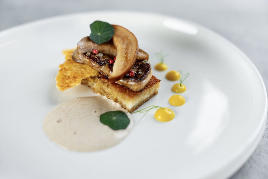 Pečené foie gras na domácím toastu s mangovým pyré, oplatkou z bílé čokolády, pěnou z lískových ořechů a nakládanou hruškou. Předkrm, který doslova voní Vánocemi.
