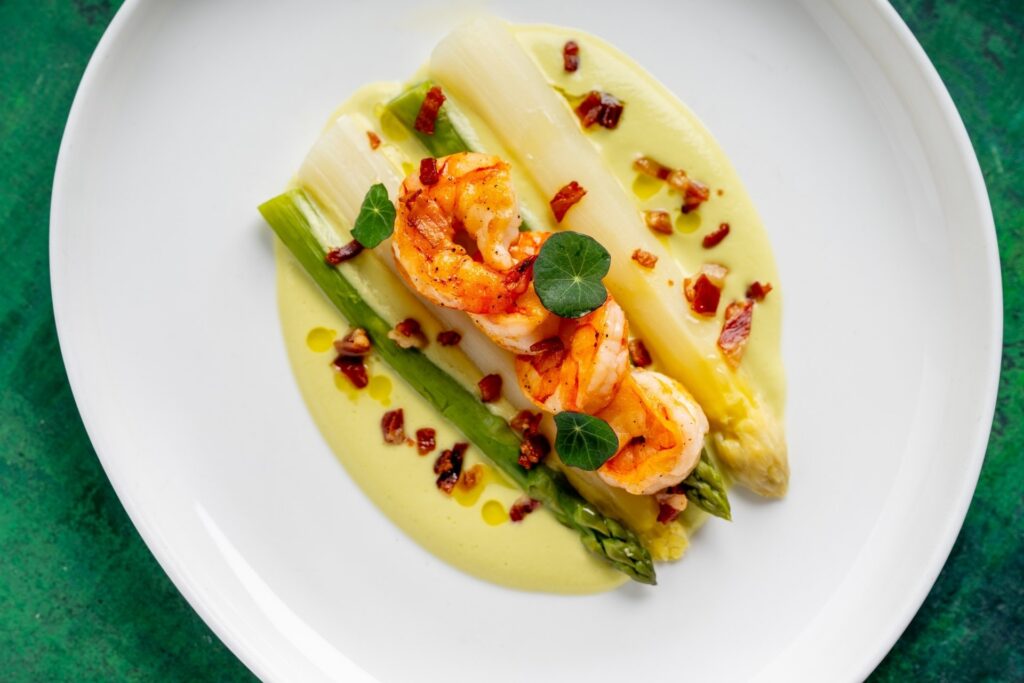 Grilované krevety se zeleným a bílým chřestem doprovází jemná omáčka z vyzrálého avokáda.