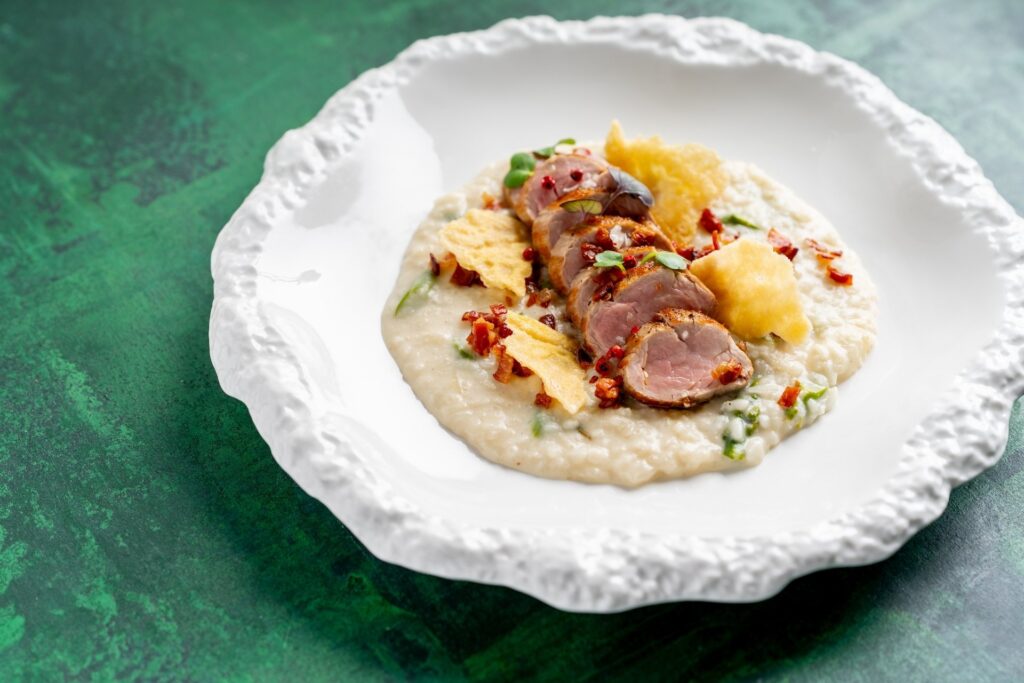 Chřestové rizoto s vepřovou panenkou a křupavou pancettou. Jeden z výtečných hlavních chodů v restauraci Na Krétě - to je naše speciální chřestové menu 2026